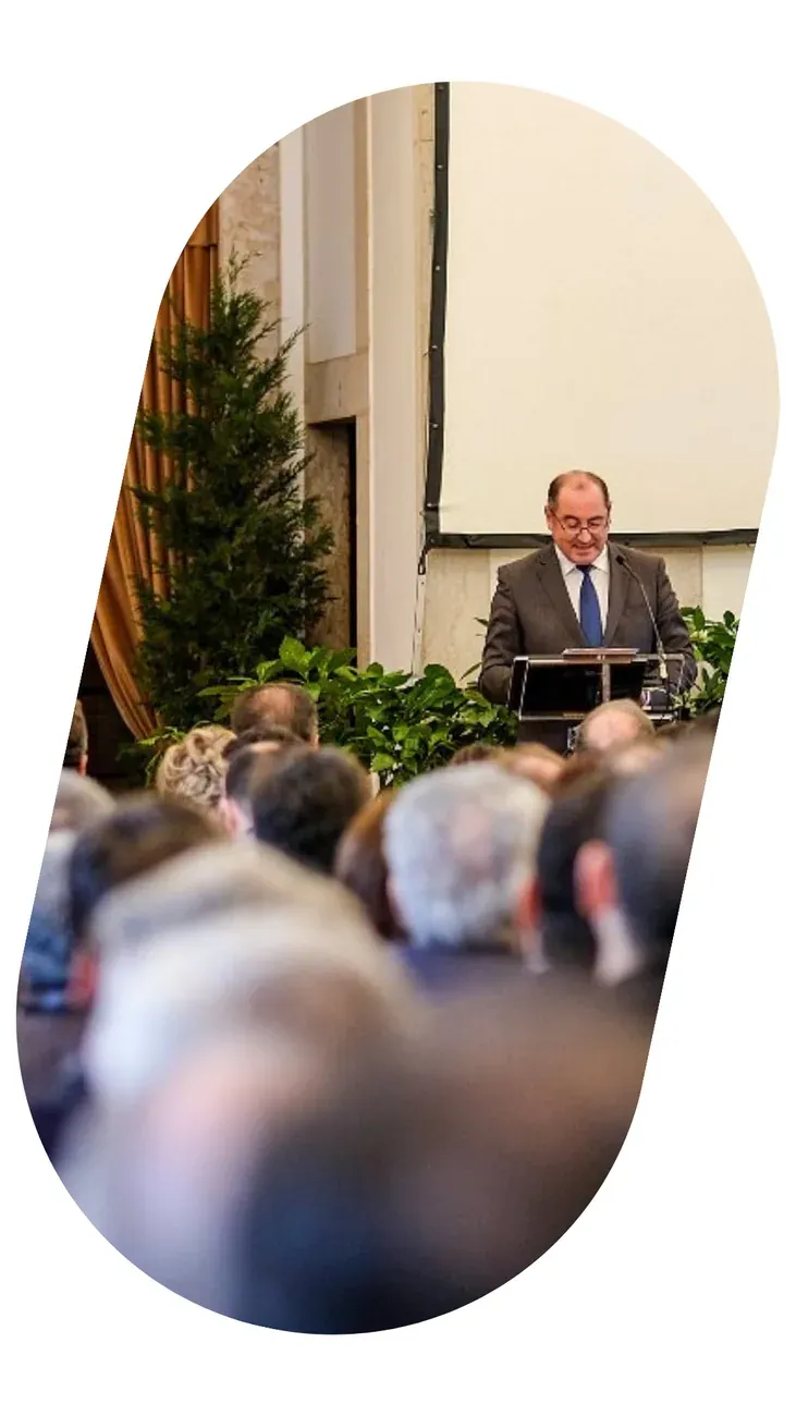 A large audience watching a speaker on stage, in a congress hall.