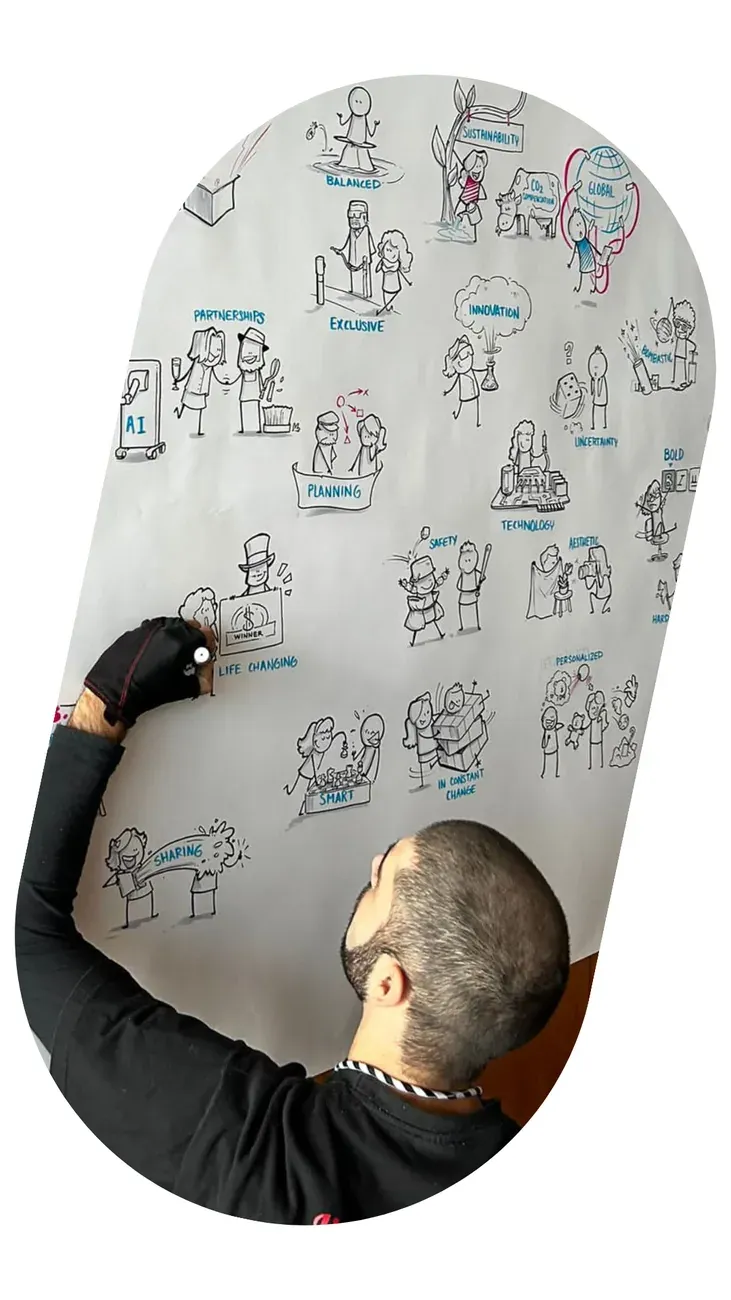 An illustrator drawing live on a whiteboard covered in figures, during a session.