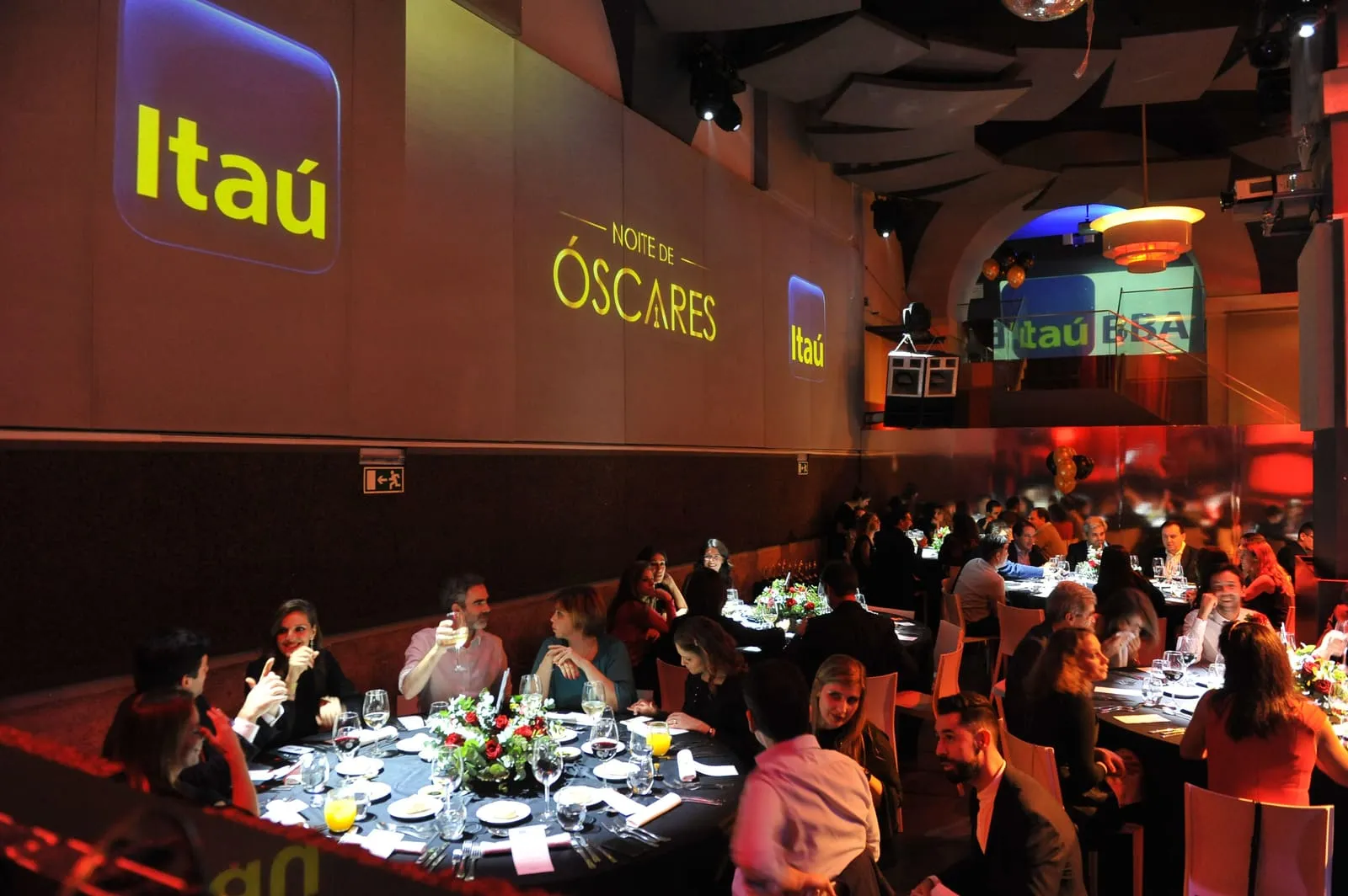 Sala de gala em tons de vermelho, com o letreiro "Óscares" e a marca do cliente nas paredes.