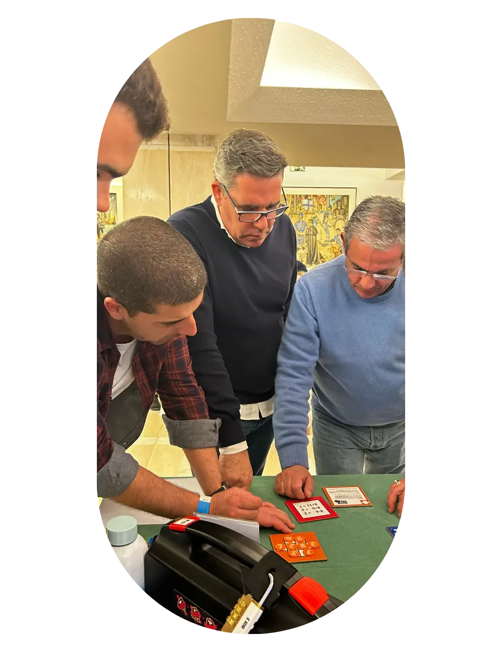 Three colleagues focused around a table, working through a challenge together.