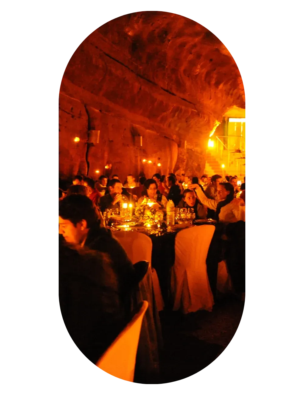 Dinner in a vaulted space lit in orange, with every table full and the room in celebration.