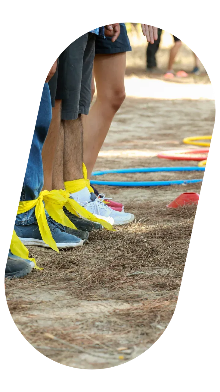 Pormenor de pés em ténis coloridos a passar por arcos pousados no chão, durante um jogo.
