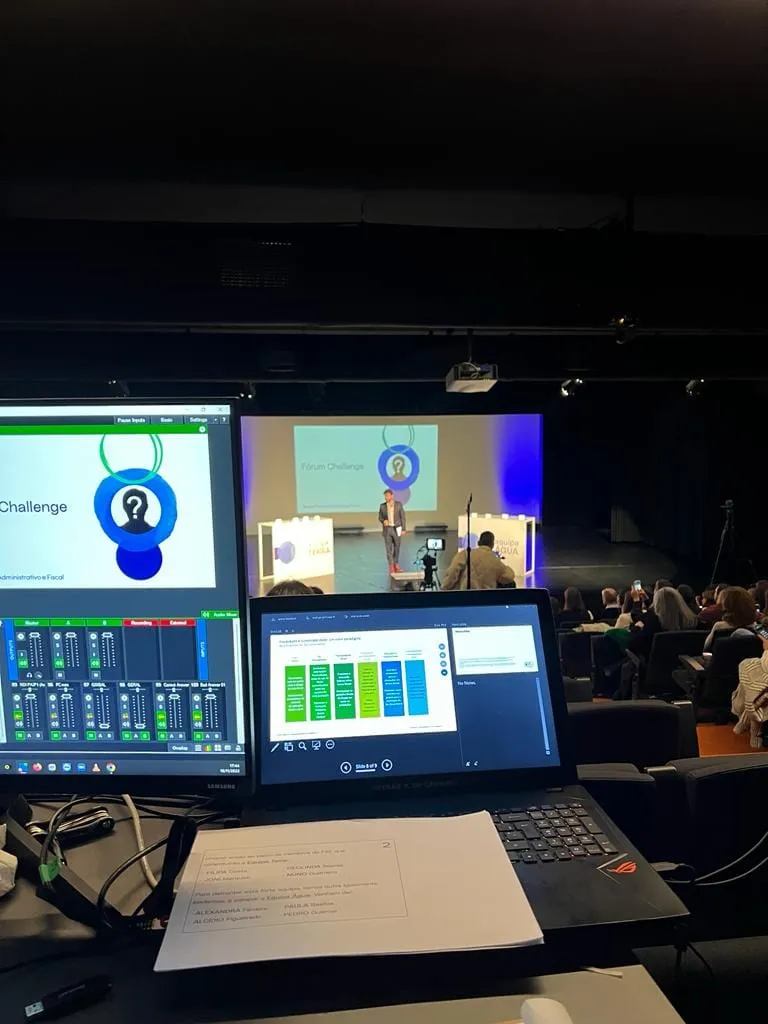The control room, with monitors and a mixing desk following the talk on stage.